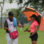 del rosario giving a bottle of water and a club in hole 14