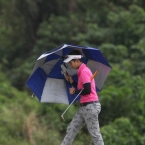 wannasiri battle for the wind as she holds on her umbrella in hole 8