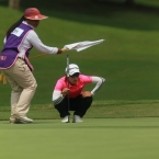 1koh sh study her line with the help of her caddie in 18