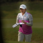 superal checking her yardage book before taking her shots